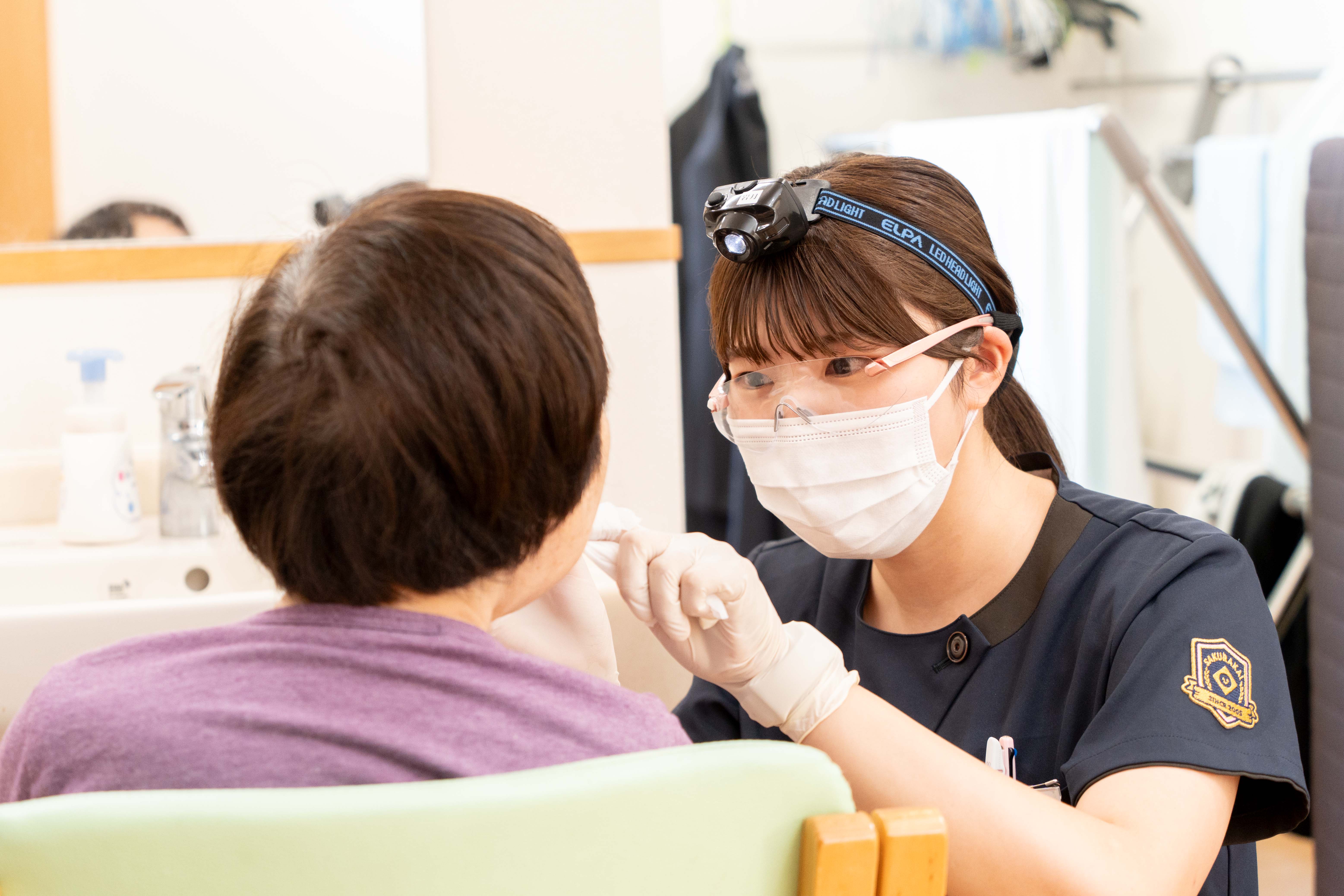 歯医者が口の中を見る様子